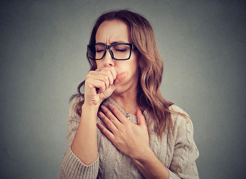 a young woman experiencing a chronic cough due to mold exposure